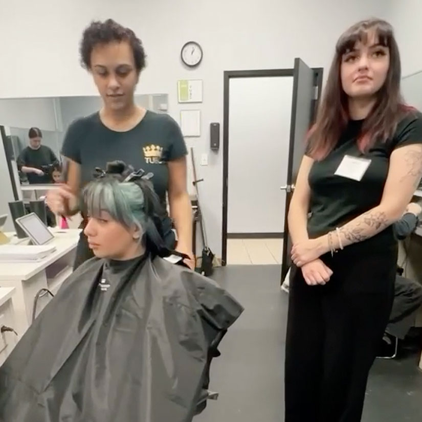 Cosmetology students practicing hair cutting skills